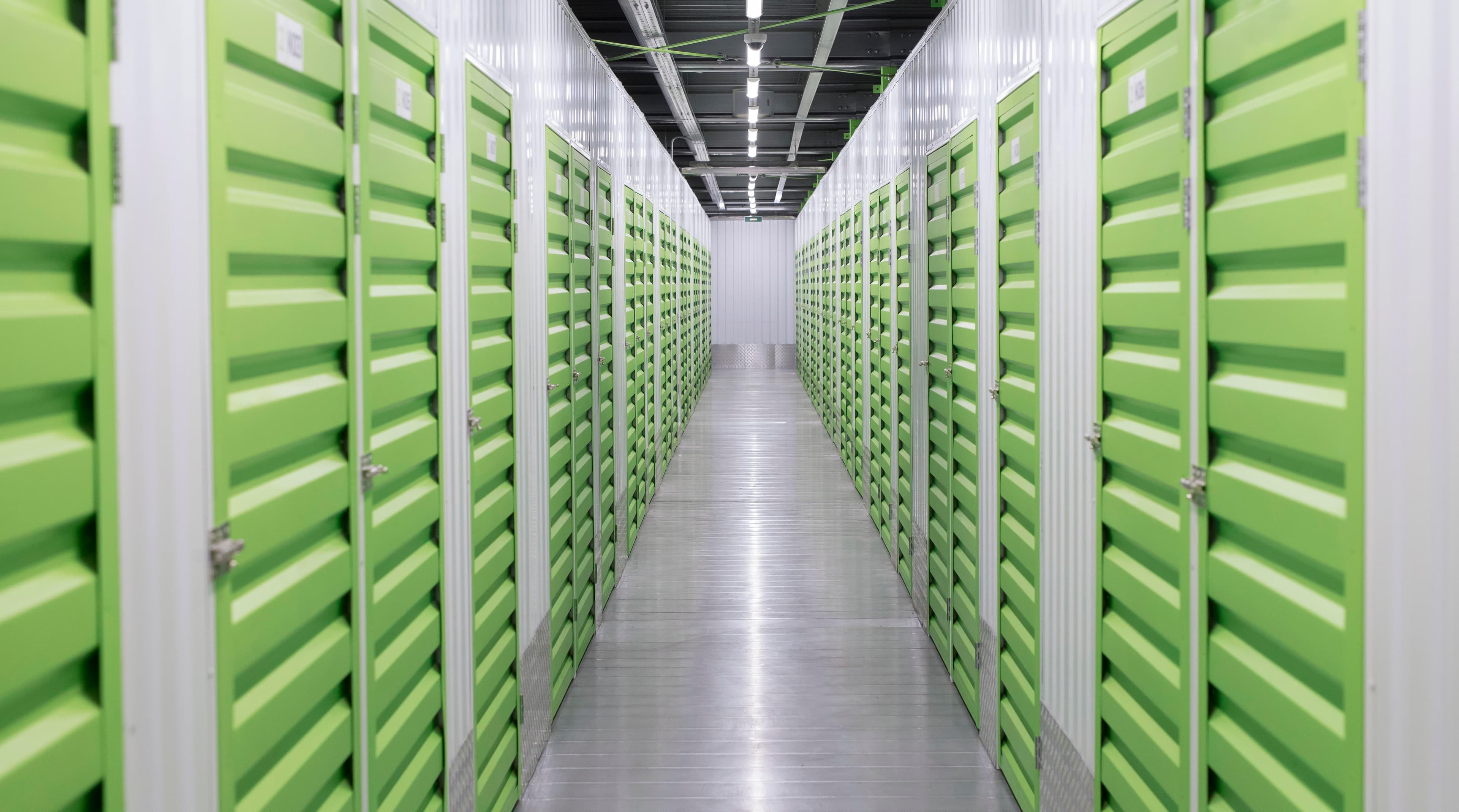 Climate-controlled self-storage corridor lined with roll-up doors inside a logistics center