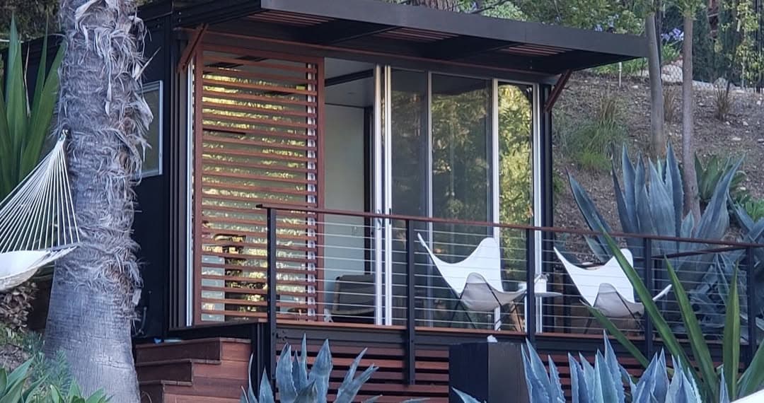 Hillside cabin with louvered wood panels and a cantilevered deck