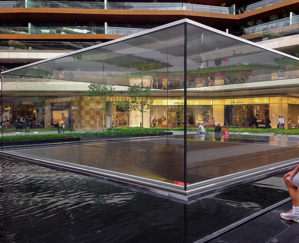Luxury brand pop-up pavilion with floor-to-ceiling glass walls at an outdoor activation